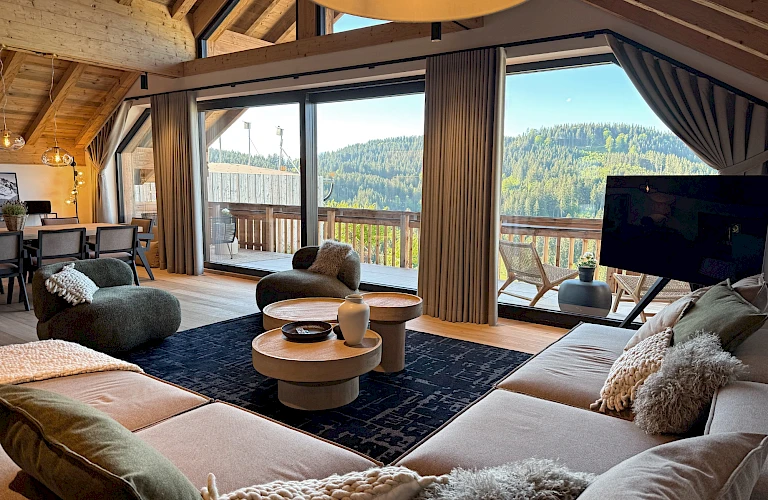Gemütliche Sofalandschaft im Chalet Mädesüss mit Ausblick in die Natur