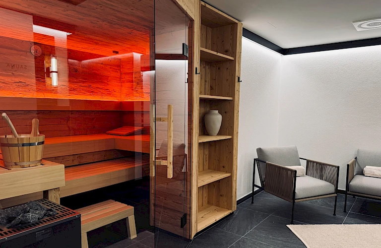 Private Sauna mit Ruhebereich und ebenerdiger Dusche